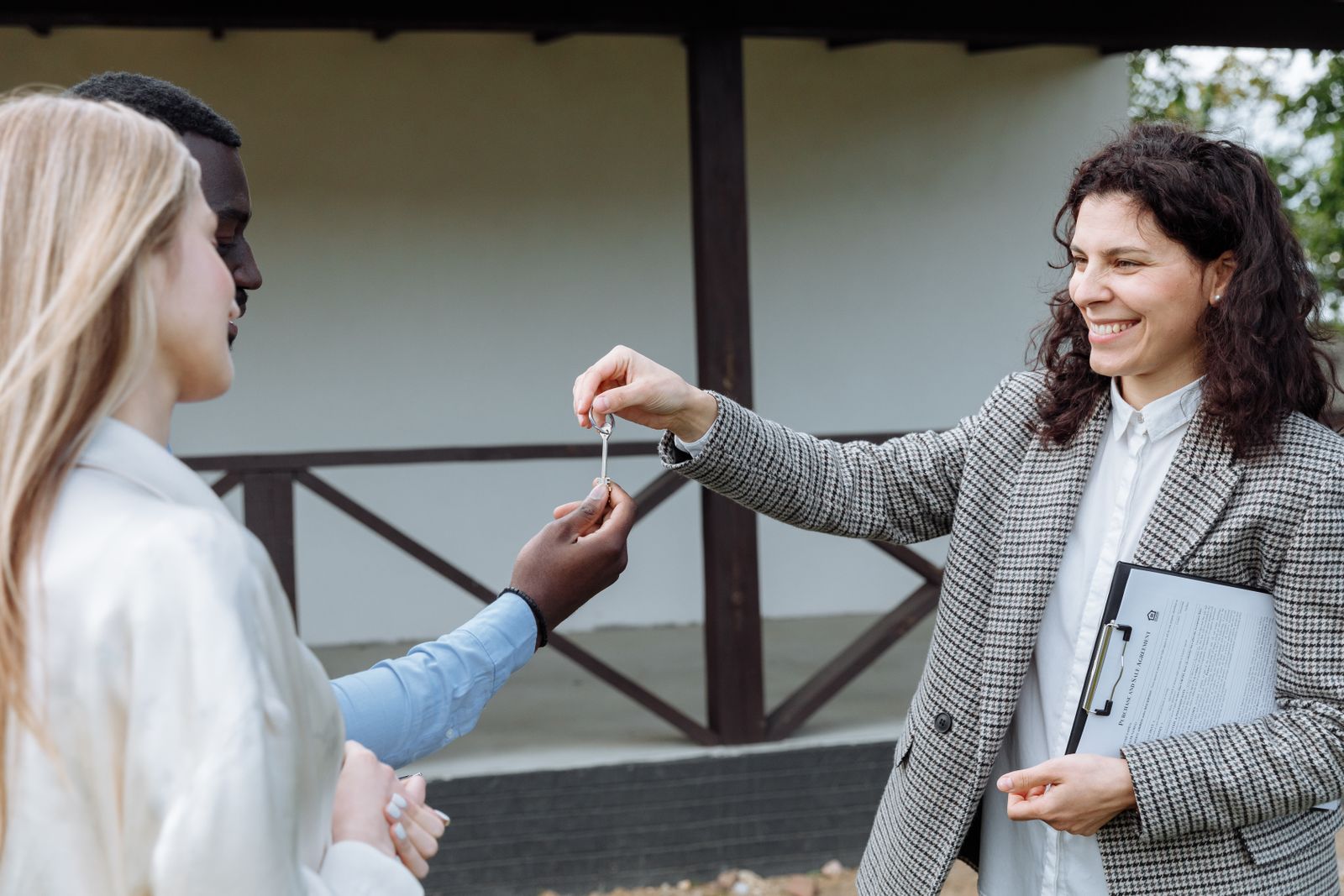 A property manager handing keys to a couple at their new rental home