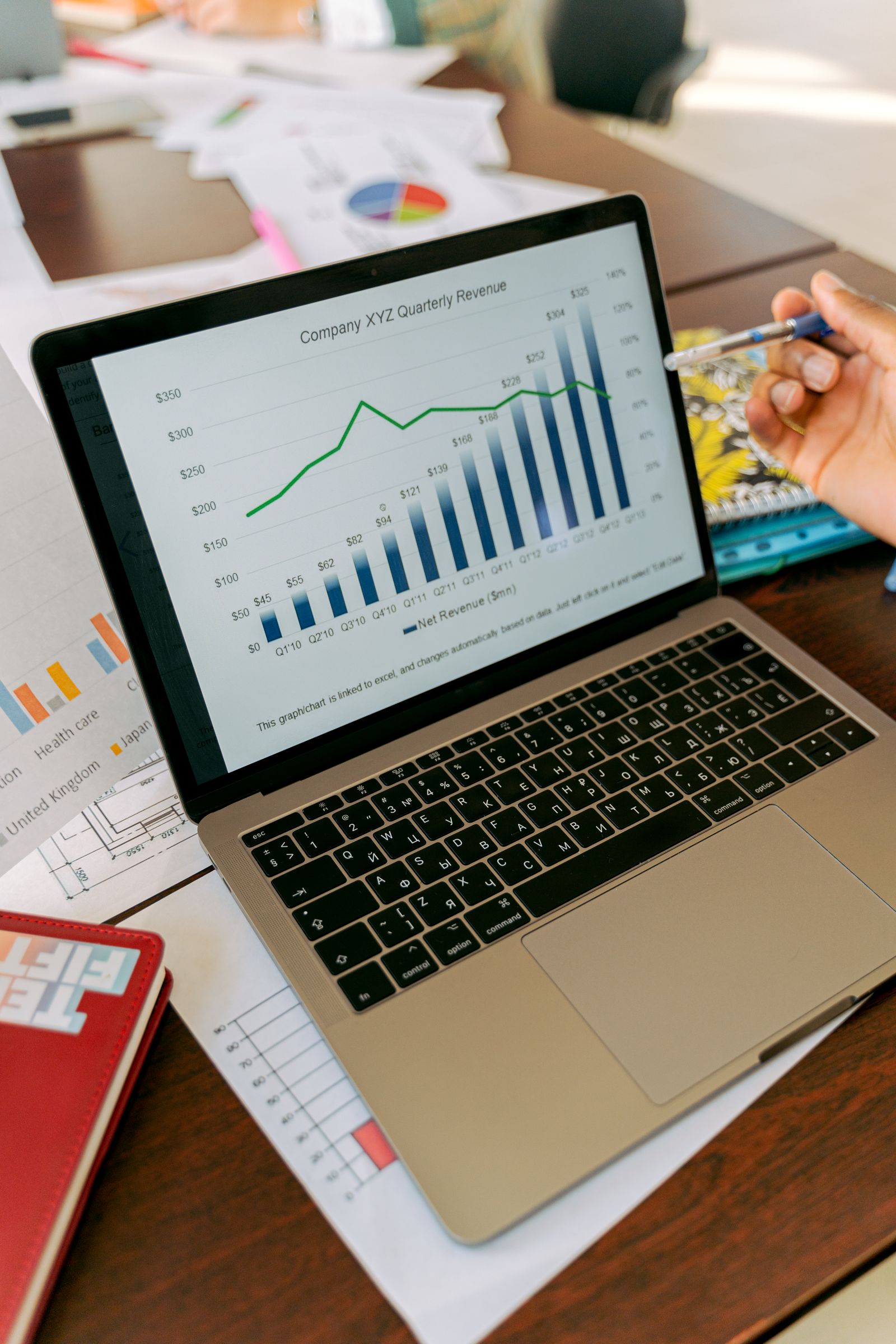 A laptop displaying financial charts and owner reporting